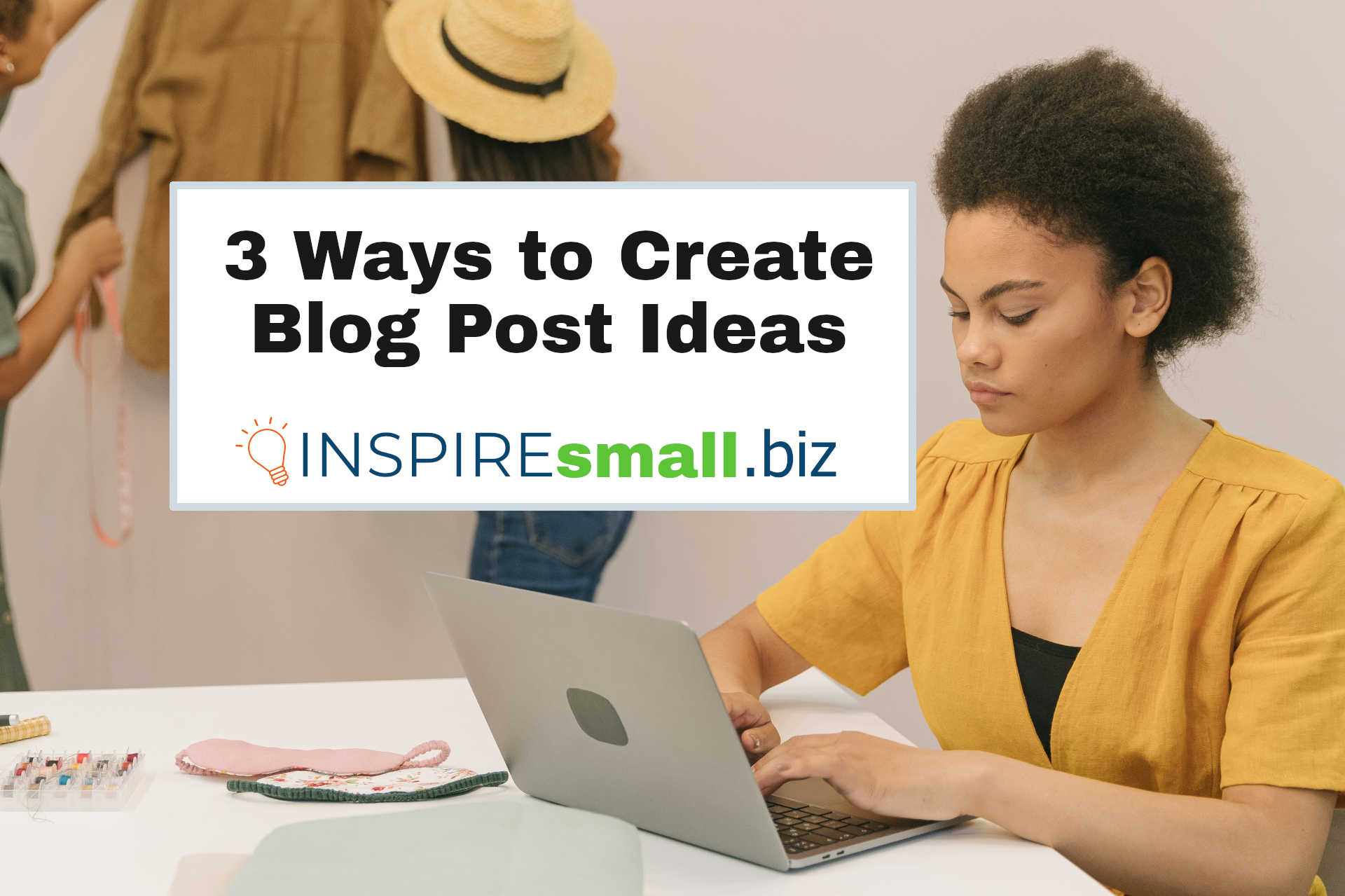 3 Ways to Create Blog Post Ideas from INSPIREsmall.biz on a white background, inset in a picture of a person working at an Apple laptop while sitting at a white table, surrounded by samples and products. There are 2 people in the background looking at a coat.