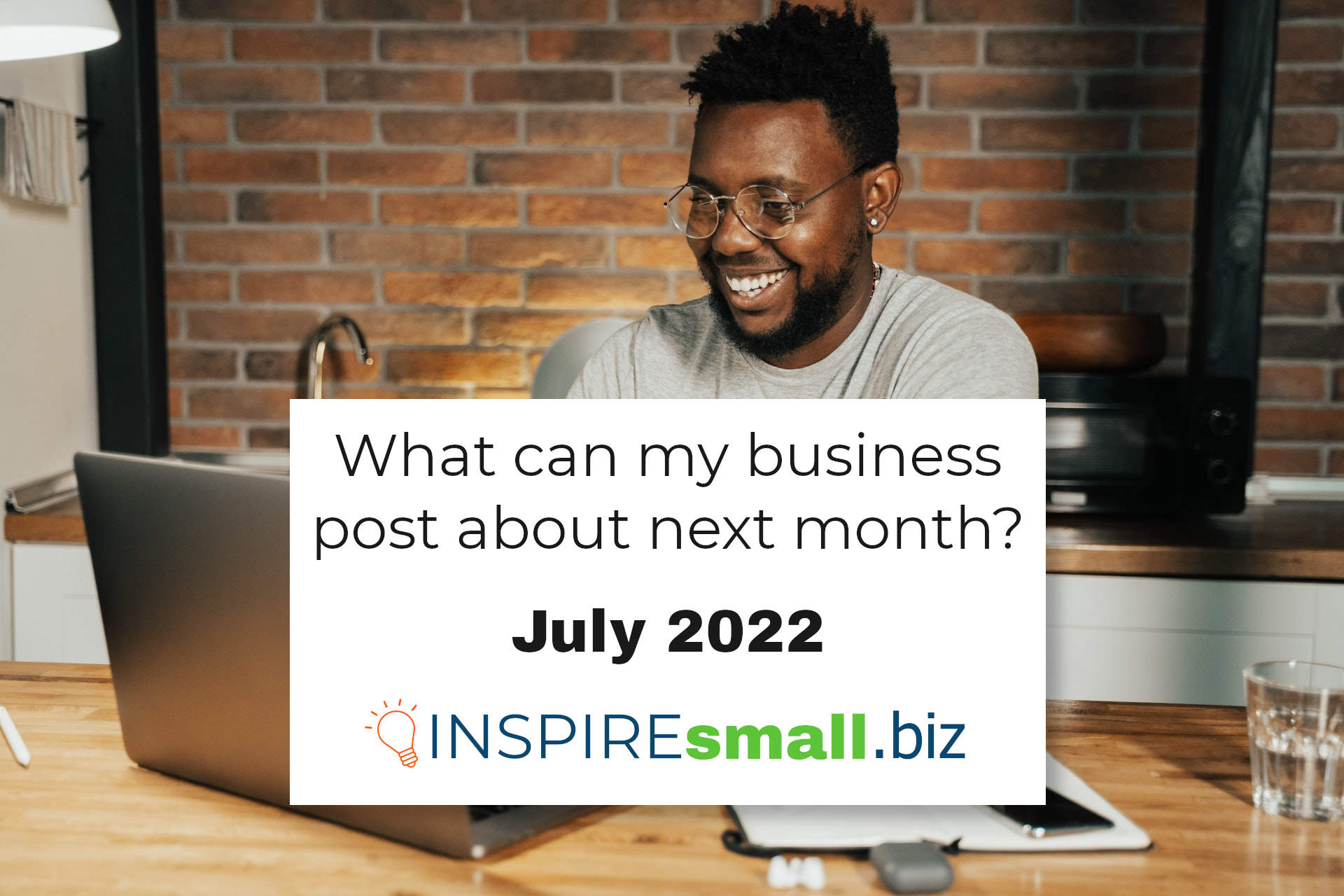 Text reading What Can My Business Post About Next Month? July 2022, from INSPIREsmall.biz over a background picture with a person sitting in front of a brick wall, at a light brown table, smiling at their computer.