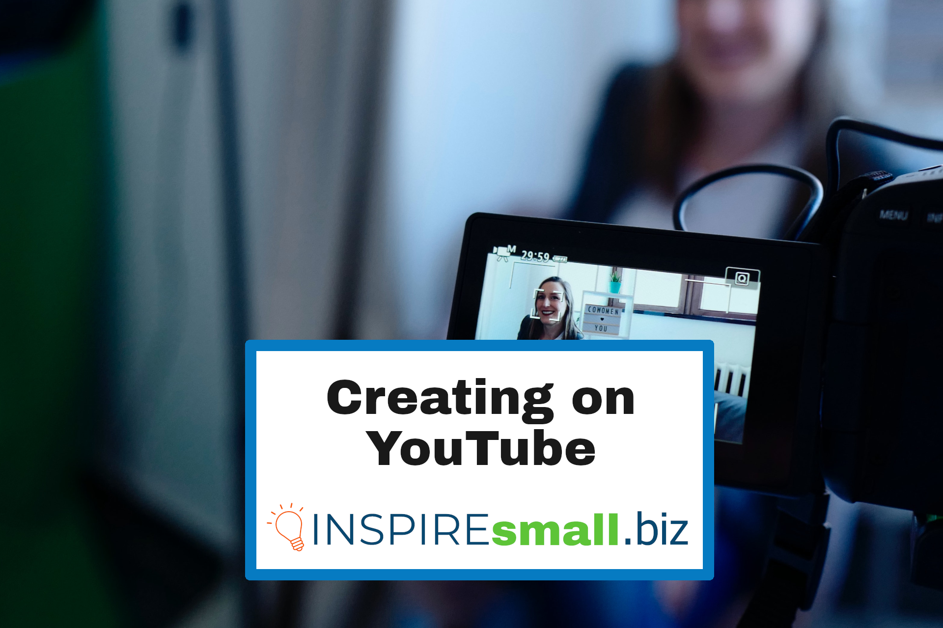 Creating on YouTube from INSPIREsmall.biz above an image of someone smiling on camera. The camera is in-focus and the rest of the shot is blurry.